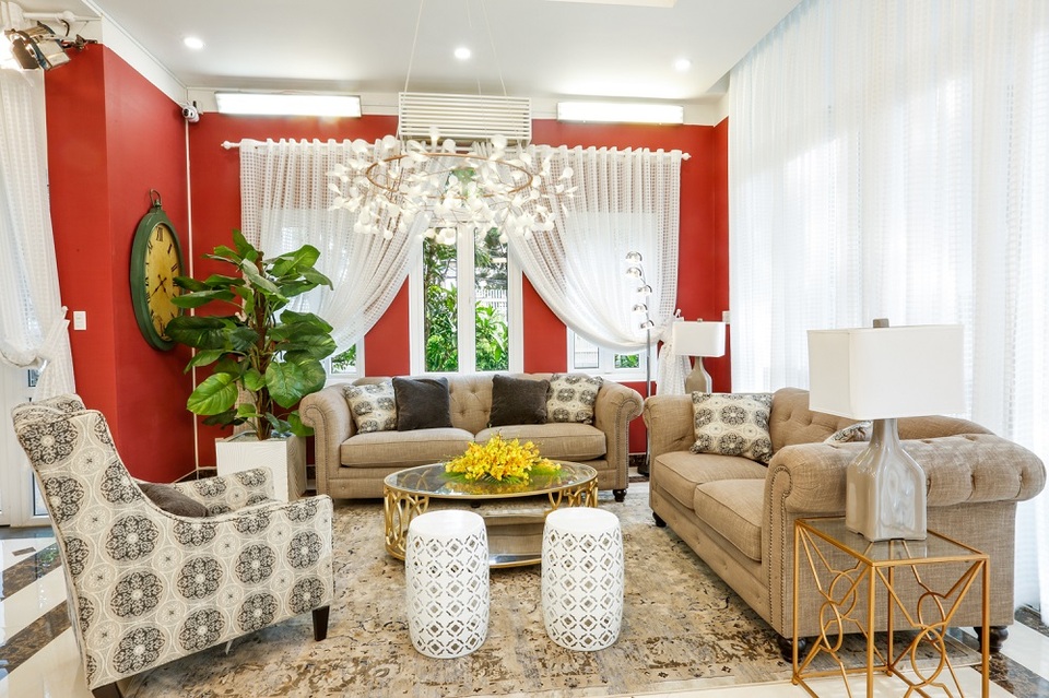 Căn biệt thự được trang trí nội thất cao cấp. Phòng khách được trang trí với gam màu nóng chủ đạo đến từ những bộ ghế sofa kết hợp cùng chiếc bàn gỗ đơn giản.