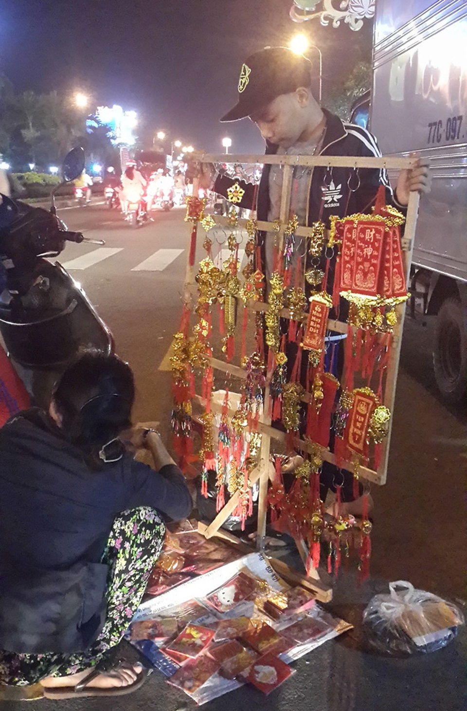 Những hình ảnh nhói lòng trong đêm Giao thừa - 15 Dưới lòng đường dòng người tấp nập, em Cương lặng lẽ mưu sinh đêm giao thừa với hy vọng kiếm tiền phụ giúp mẹ lo tiền thuốc men cho bà ngoại