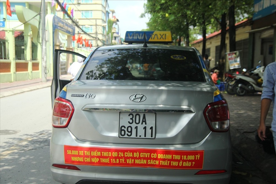 Đại chiến taxi truyền thống với Grab, Uber: Tài xế taxi "một cổ nhiều tròng" - 1
Taxi dán khẩu hiệu phản đối Quyết định 24 của Bộ GTVT. Ảnh: Cường Ngô