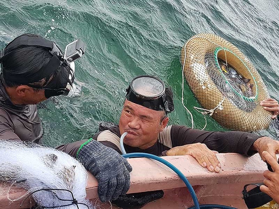 Anh Nguyễn Hữu Thái cùng bạn lặn là anh bảy Lĩnh đi lặn bắt cá. Cả hai đều đã dần bỏ nghề để nuôi cá. Ảnh: HM