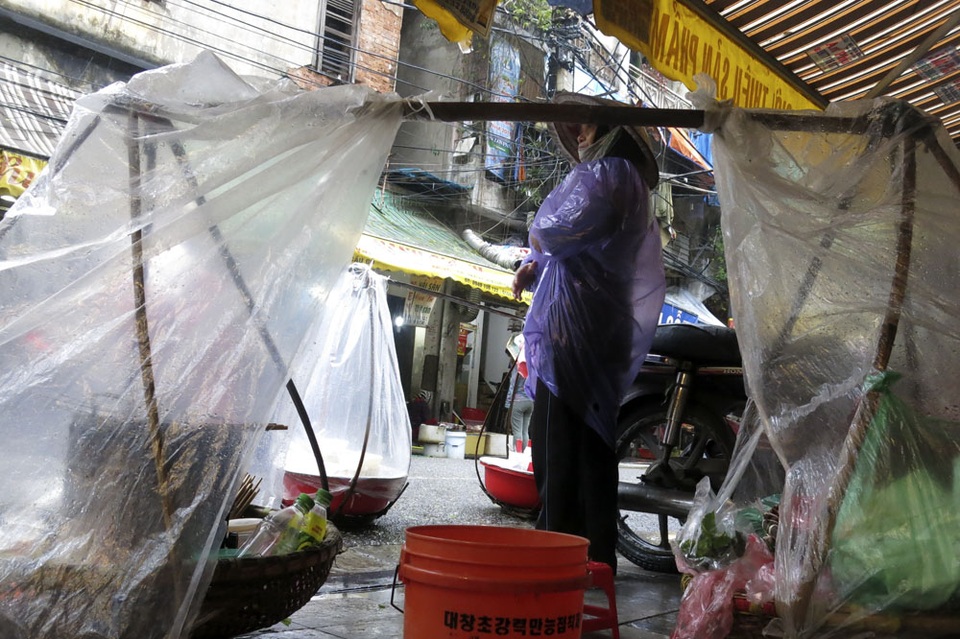 Nhịp sống Hà Nội trong mưa lạnh triền miên - 10
Gánh hàng ăn uống của người bán rong được che áo mưa cẩn thận.