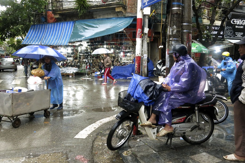 Nhịp sống Hà Nội trong mưa lạnh triền miên - 12 Người lái xe ôm đội mưa chờ khách, công việc kiếm sống hàng ngày trở nên vất vả hơn nhiều.