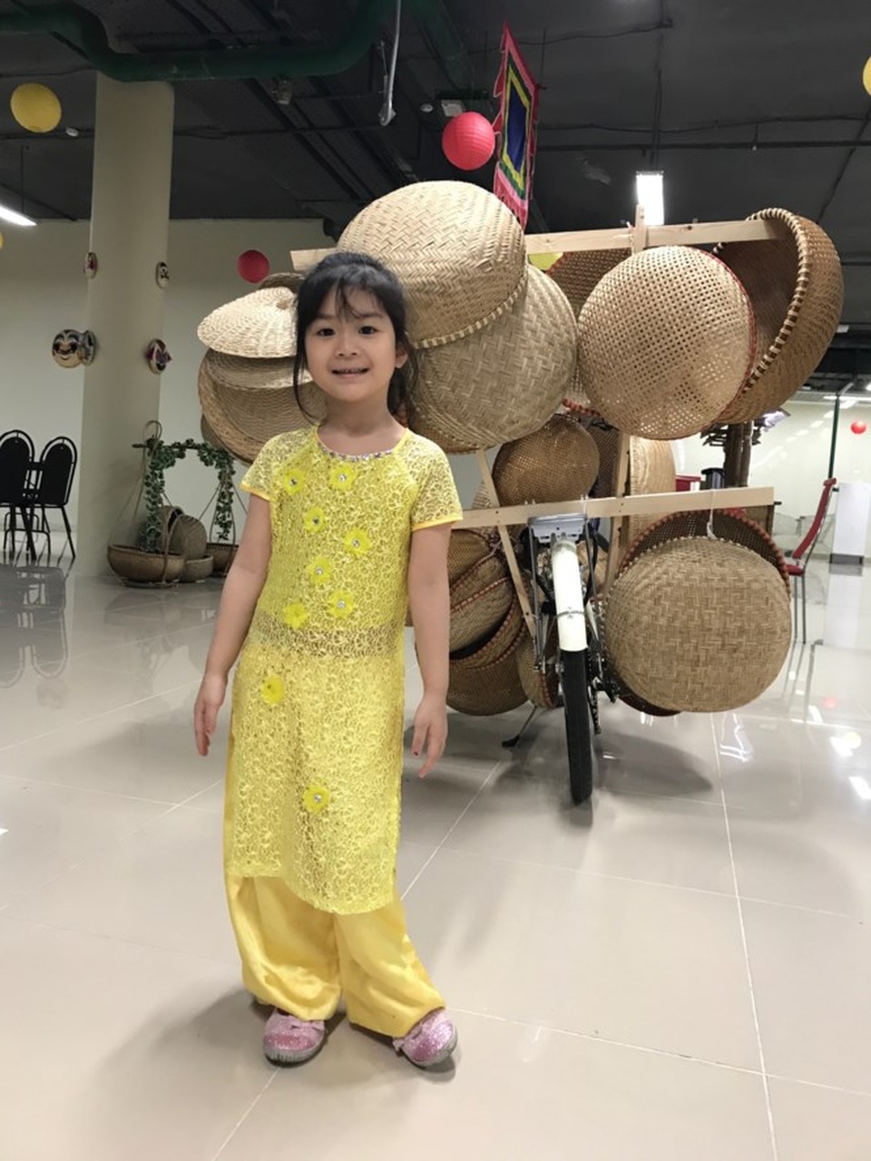 Một em bé Việt Nam phấn khởi cùng người lớn đến chuẩn bị Lễ hội.