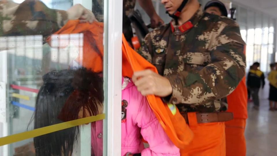 Bé gái Trung Quốc kẹt cứng đầu trong khe hẹp giữa 2 cửa kính - 3 Lính cứu hỏa phải tháo dỡ bản lề của cửa kính để có thể kéo đầu em ra mà không bị đau đớn