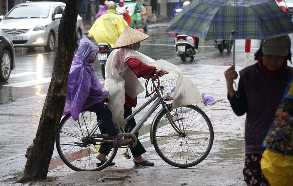 Nhịp sống Hà Nội trong mưa lạnh triền miên - 3 Không chỉ mưa, thời tiết cũng lạnh khiến các em nhỏ phải mặc áo mưa kín mít để đến trường.