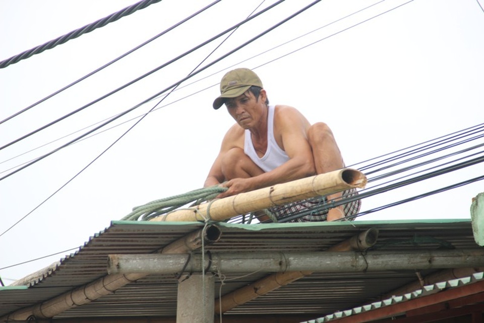 Miền Trung bắt đầu mưa, dân hối hả chạy "siêu bão" - 15 Một người dân buộc lại mái nhà