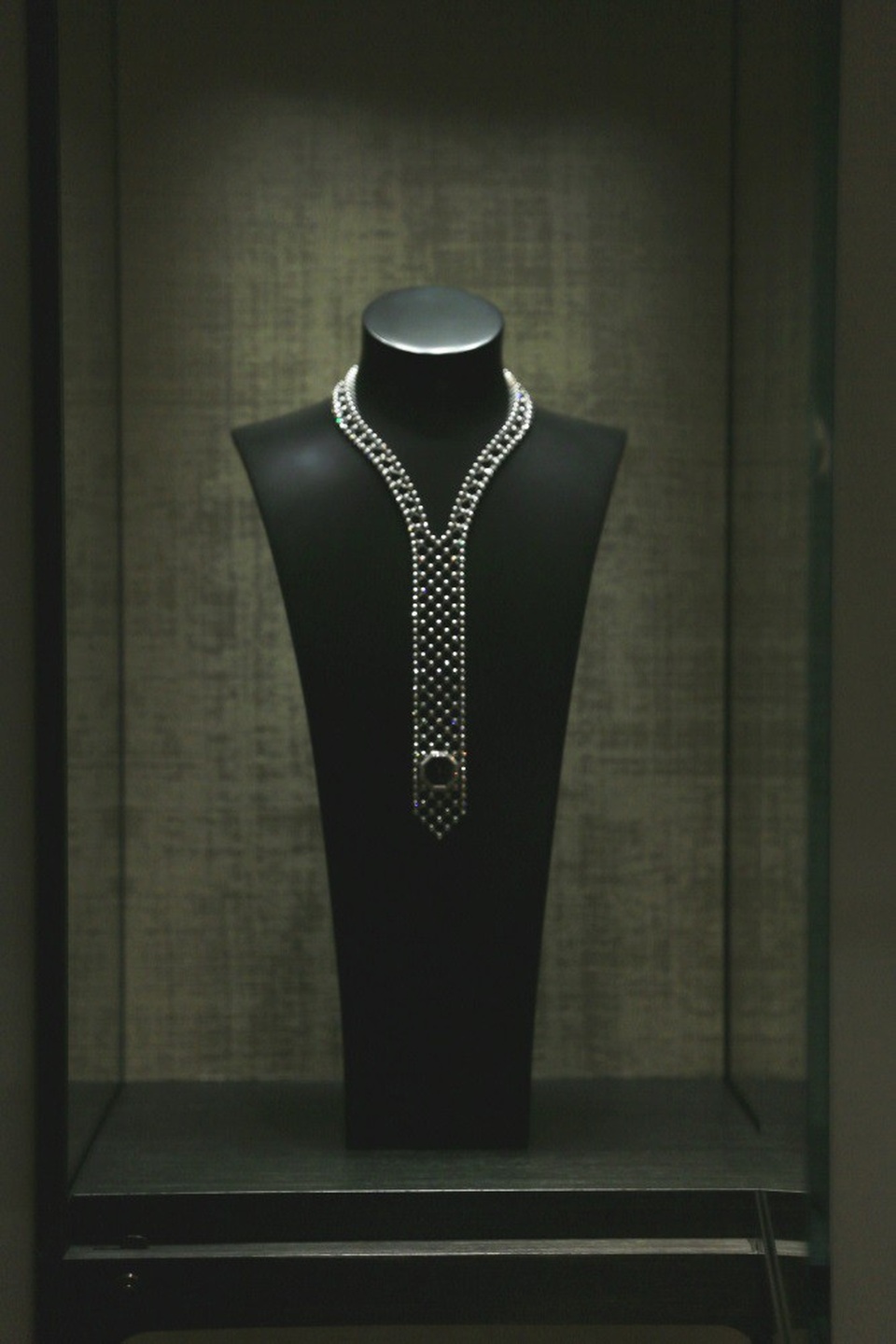 Không ai muốn luôn luôn nhắc đến thời gian trôi qua, nhất là trong những khoảnh khắc của hạnh phúc. Chiếc đồng hồ dây chuyền vàng trắng 18K đính 404 viên kim cương tròn thoạt nhìn giống như một chiếc cà vạt tạo thành món trang sức đầy ánh sáng, mặt đồng hồ được đính nhỏ xíu màu đen chỉ giống một sự ngụ ý kín đáo về thời gian