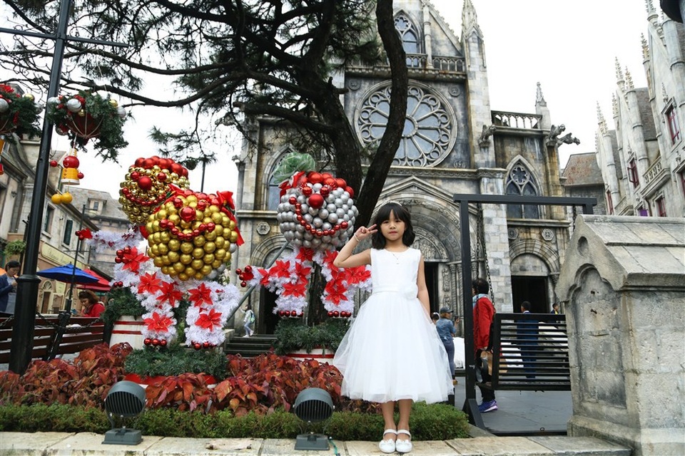 Trước thánh đường St. Denis, những người tuyết phiên bản Sun World Ba Na Hills ngộ nghĩnh, đáng yêu được kết tạo từ những bông trạng nguyên và quả châu rực rỡ khiến các du khách nhí vô cùng phấn khích.