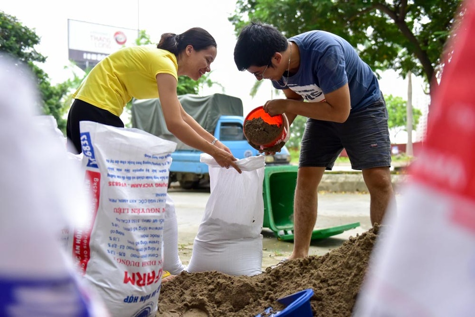Hà Nội: Người dân hối hả “đắp đê” trước cửa nhà phòng mưa ngập sau bão - 4
Vợ chồng chị Vũ Thị Hương cho biết, nghe tin bão số 10 rất mạnh, từ sáng sớm chị đã mua cát và bao tải về đóng thành bao cát lớn, đắp thành một hàng trước cửa nhà. Đợt mưa lớn cách đây ít tháng, toàn bộ nhà dân tại đây bị ngập sâu cả mét, nước ngập toàn bộ các tầng hầm, thiệt hại và phiền toái để lại là rất lớn, chị Hương cho biết.