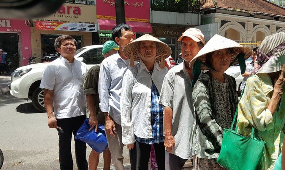 Vợ chồng nguyên Chủ tịch nước ăn cơm 2.000 đồng cùng người nghèo - 3 Ông Đoàn Ngọc Hải, Phó Chủ tịch quận 1 (người đứng cuối) xếp hàng vào ăn cơm