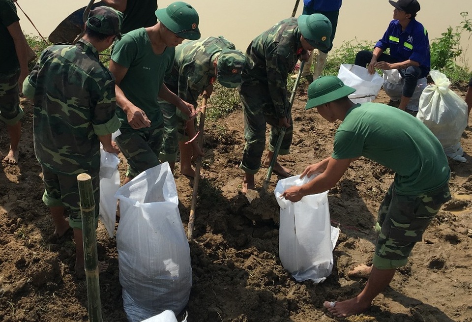Vật lộn trong lũ chèn đá hộc, đóng cọc gia cố chân đê - 14 Cho đất vào bao tải để đắp đê