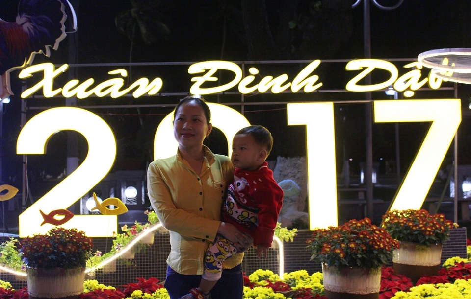 Người dân cả nước hân hoan trong phút giao thừa - 56 Người phụ nữ bế con lưu lại kỷ niệm ở một điểm trang trí Tết trên đường Trần Phú trước thời khắc đón năm mới Đinh Dậu - Ảnh: Viết Hảo