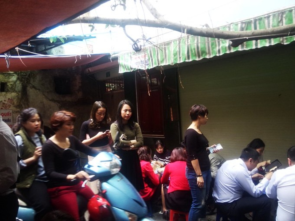 Bội thực giò thịt, dân đứng đợi 30 phút để được ăn bún cá - 5 Lướt điện thoại là phương pháp hữu hiệu giải tỏa căng thẳng trong lúc chờ chỗ ngồi. Ảnh: Diệu Bình