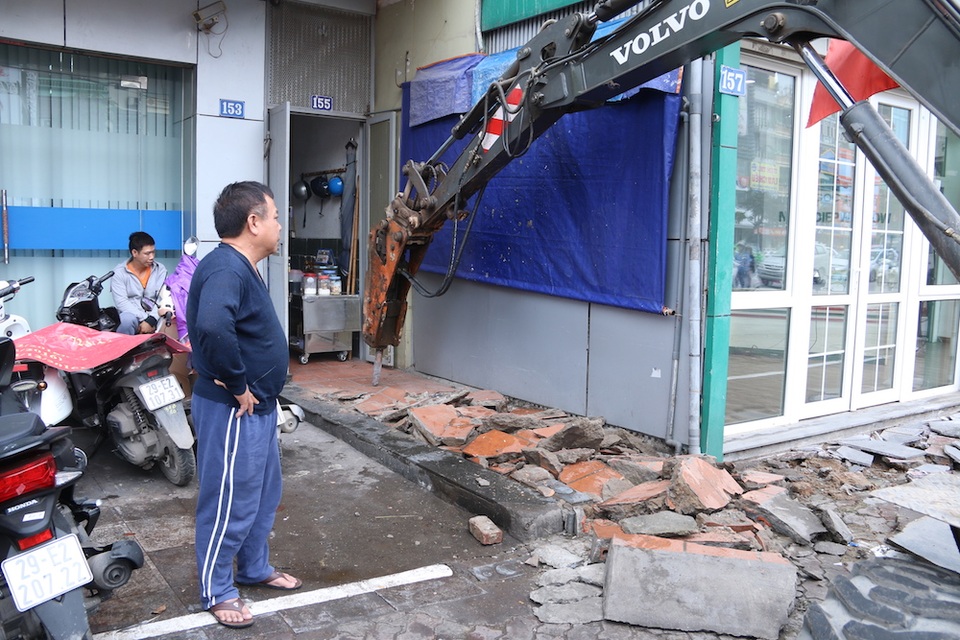 Muôn kiểu "chế" bậc tam cấp trên vỉa hè của người Hà Nội - 14
Chủ nhân của căn nhà 155 Xã Đàn đứng nhìn máy phá bê tông phá đi phần vỉa hè mà gia đình ông đã sử dụng trong thời gian qua. Trong khi đó gia đình bên cạnh có phần xây mới cùng với chiều dài phần vỉa hè mà gia đình ông lấn chiếm nhưng lại không bị đập bỏ.