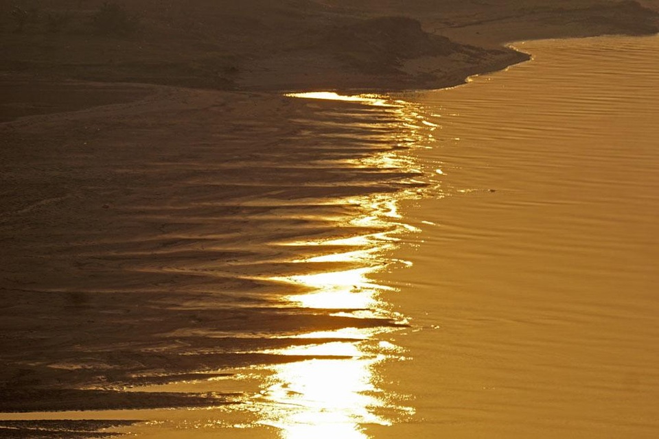 Bãi bồi ven sông cũng ngả sang màu vàng rực rỡ của ánh bình minh.