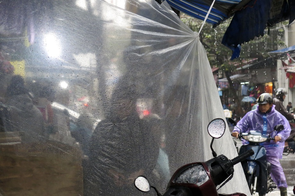 Nhịp sống Hà Nội trong mưa lạnh triền miên - 7 Nhiều cửa hàng mặt phố buôn bán đều phải che chắn thêm tránh gió tạt nước làm ướt hàng hóa.