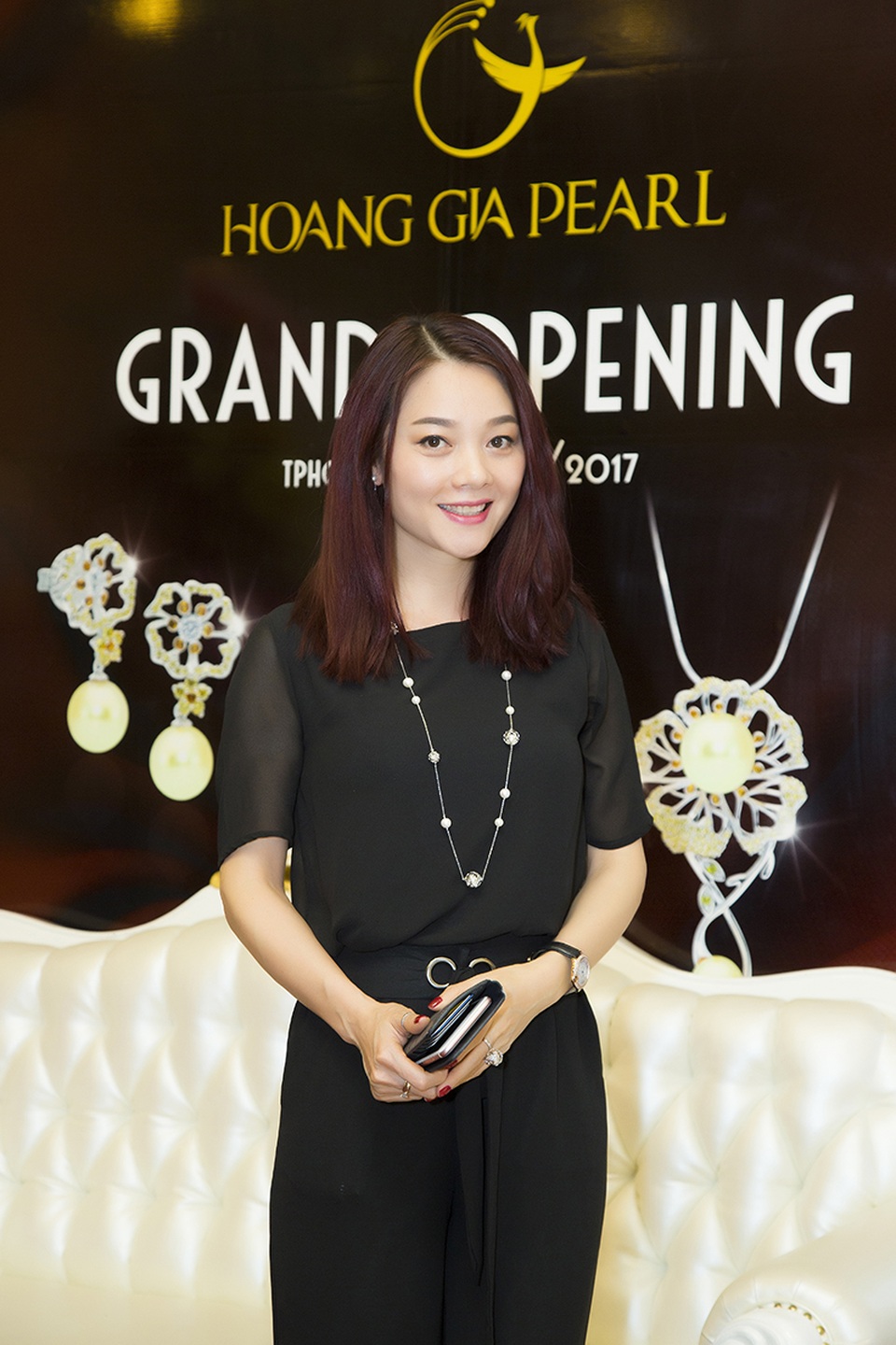 Hoa hậu Quý bà Hoàng Yến diện bộ jumpsuit đen, đeo trang sức ngọc trai nổi bật.