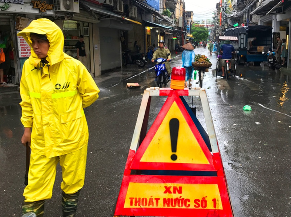 Khách Tây lạ lẫm xem phố cổ Hà Nội thành "biển nước" sau bão - 8 Công nhân thoát nước túc trực chờ nước rút tại các điểm ngập.
