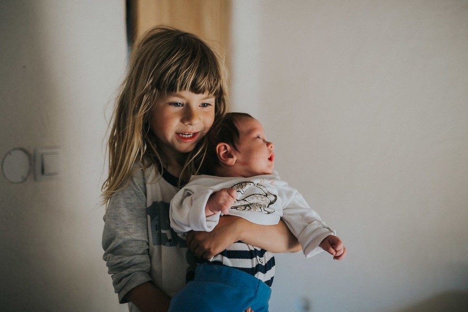 Chị gái giúp bố mẹ trông em