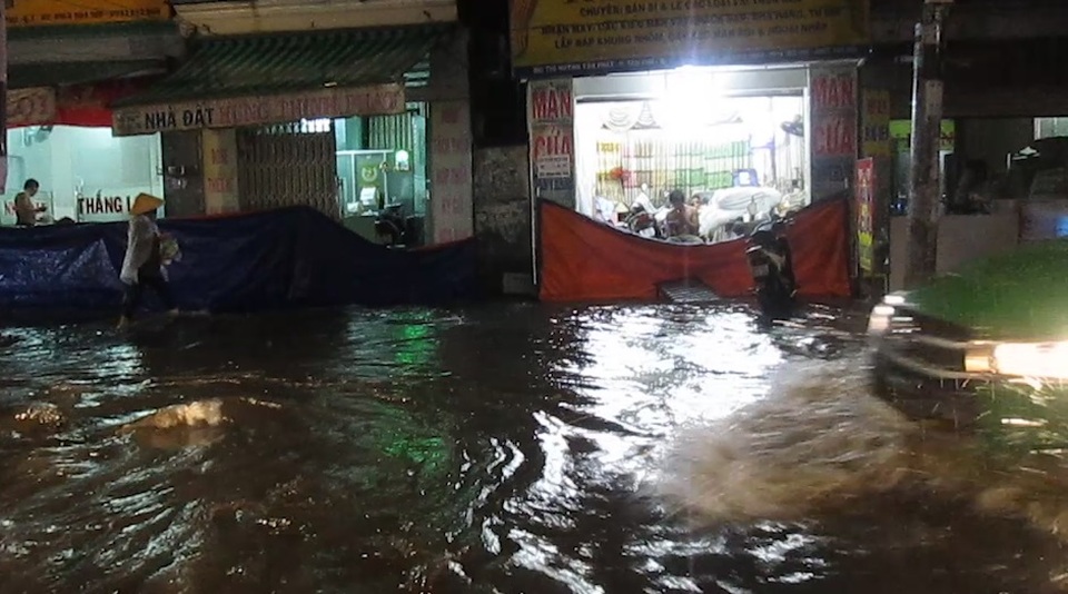 Nhà dân ven đường phải dùng bạt để chắn trước cửa không cho nước tràn vào nhà