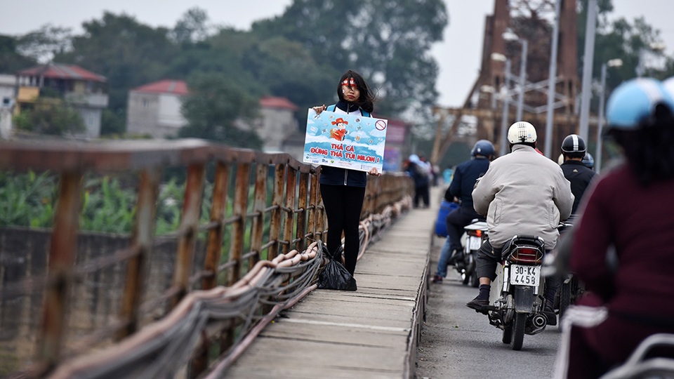 Cá chép tấp nập đi... lên trời - 8 Trên cầu luôn có một nhóm sinh viên tình nguyện thuyết phục người thả cá giữ môi trường với khẩu hiệu Thả cá đừng thả túi nilon”.