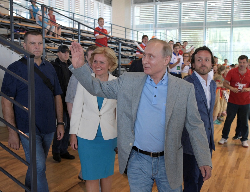 Tổng thống Putin tới thăm Crimea sau lệnh trừng phạt của Mỹ - 11 Tổng thống Putin vẫy tay chào các em nhỏ khi tới thăm một phòng tập thể thao tại Trại Artek.