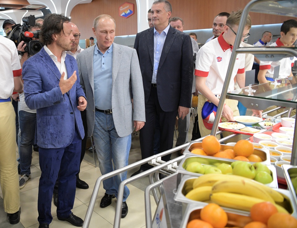 Tổng thống Putin tới thăm Crimea sau lệnh trừng phạt của Mỹ - 7 Tổng thống Nga cũng tới thăm khu vực nhà ăn dành cho các em học sinh tại Trại Artek. Đi cùng ông Putin là lãnh đạo của Crimea Sergei Aksyonov (áo vest đen) và Giám đốc Trại Artek Alexei Kasprzhak (trái).