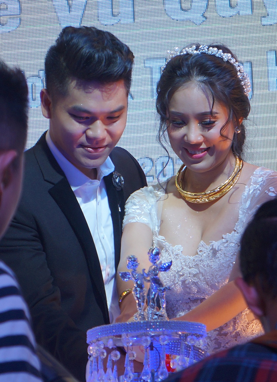 Cả hai cùng thực hiện nghi thức cắt bánh trong tiệc cưới.