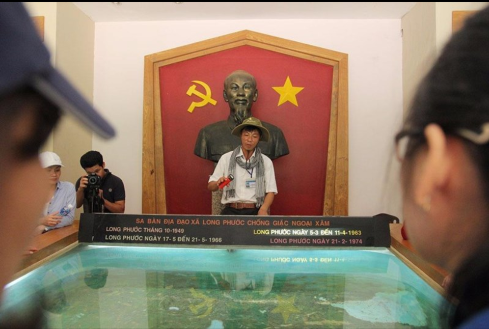 
Anh Đức, hướng dẫn viên tại địa đạo Long Phước, xã Long Phước, đang kể lại câu chuyện về bác Năm Hồi.
