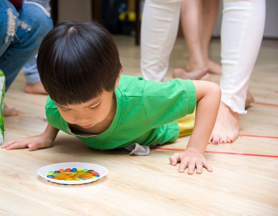 STEM, STEAM cách học của trẻ mầm non mà bố mẹ nên biết - 2 Bé chăm chú quan sát sự biến đổi của những viên kẹo màu khi được tự làm thí nghiệm“sự tan và loang màu”.