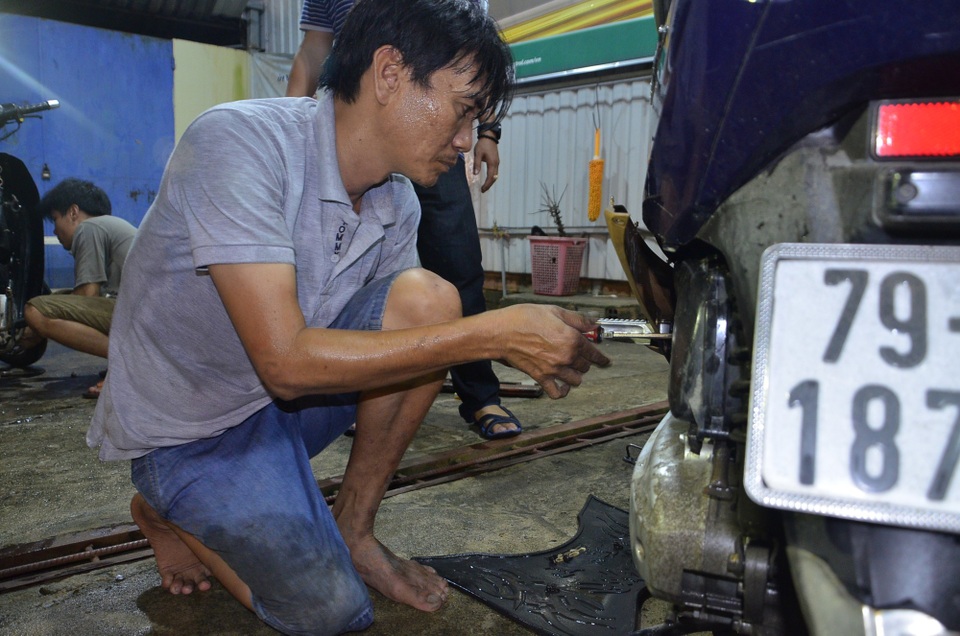 
Anh Trung cặm cụi làm công việc sửa xe miễn phí dù chân bị tật, đi lại khó khăn.
