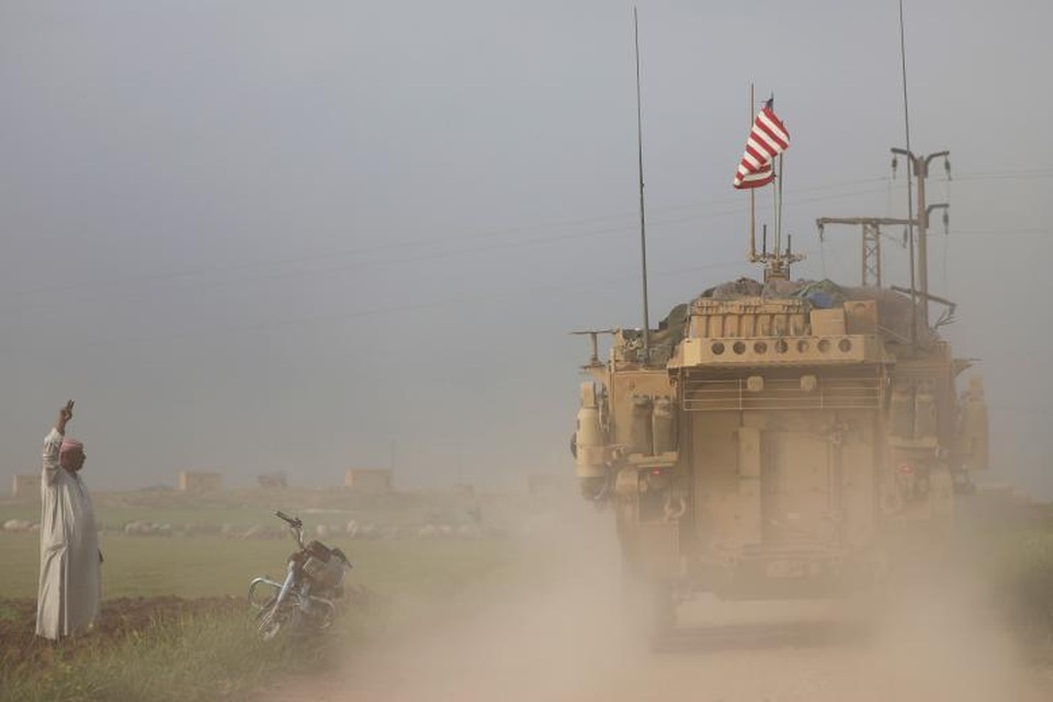 Lực lượng quân đội Mỹ tại “chảo lửa” Syria - 7 Theo CNN, tính đến tháng 3/2017, cuộc chiến tàn khốc tại Syria đã khiến hơn 5 triệu người Syria phải rời bỏ đất nước và khoảng 6,3 triệu người mất nhà cửa. Ngoài ra, tính từ khi cuộc nội chiến xảy ra từ năm 2011 đến nay, ước tính có khoảng 400.000 người Syria thiệt mạng và hàng triệu người khác bị thương. Trong ảnh: Một người đàn ông địa phương tại thị trấn Darbasiya của Syria, nằm gần biên giới với Thổ Nhĩ Kỳ, đứng cạnh một xe quân sự của Mỹ hồi tháng 4.