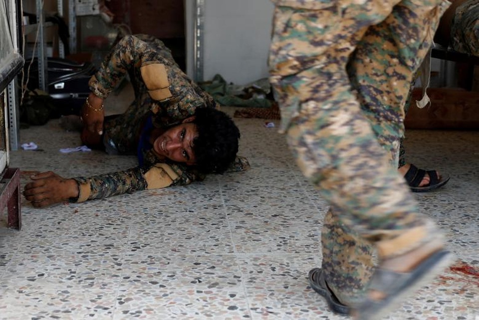 Bên trong bệnh viện dã chiến ở “chảo lửa” Syria - 2 Các phần tử thánh chiến IS đã tràn vào Raqqa từ năm 2014 và coi thành phố này là thủ phủ của chúng tại Syria.Trong ảnh: Một binh sĩ SDF bị thương nằm bên trong một bệnh viện dã chiến tại Raqqa sau khi trúng đạn của một tay súng bắn tỉa IS.