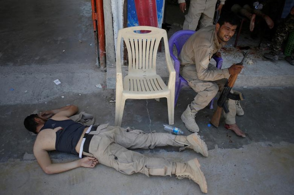 Bên trong bệnh viện dã chiến ở “chảo lửa” Syria - 5 Các binh sĩ SDF bị thương sau khi trúng hỏa lực từ súng cối của phiến quân IS ngồi chờ tới lượt điều trị ở bên ngoài một bệnh viện dã chiến tại Raqqa.