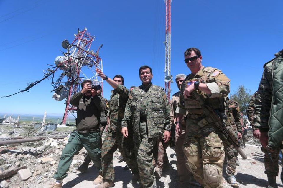 Lực lượng quân đội Mỹ tại “chảo lửa” Syria - 9 Một chỉ huy của lực lượng quân đội Mỹ (phải) và một chỉ huy của Các Đơn vị Bảo vệ Nhân dân người Kurd (YPG) (giữa) cùng nhau thị sát khu vực bị tàn phá sau cuộc không kích của Thổ Nhĩ Kỳ ở Mount Karajukh, Syria hôm 25/4.