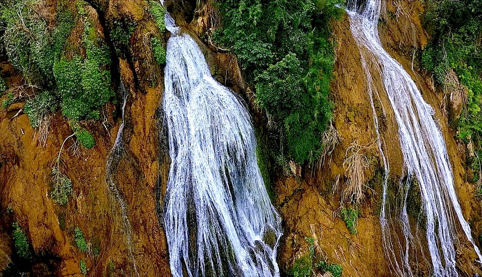 Thoạt trông thì dòng thác chảy mềm mại như một dải lụa trắng buông mình quanh co từ trên cao xuống chân núi.