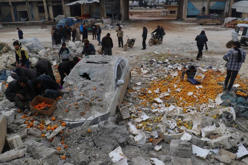 Thế giới qua một năm nhiều biến động (2) - 4
Người dân ở thành phố Maarrat Misrin, tỉnh Idlib của Syria hôi của sau khi một khu chợ ở đây trở thành mục tiêu không kích.