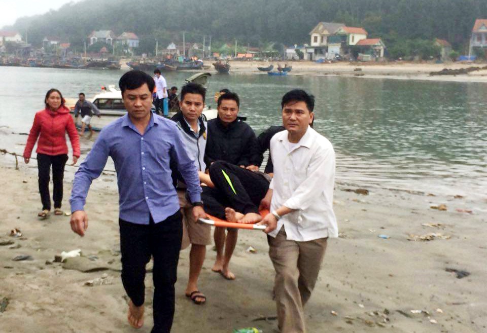 Lực lượng chức năng đưa người bị thương đi lên bờ, đến bệnh viện điều trị (ảnh H.Tình).