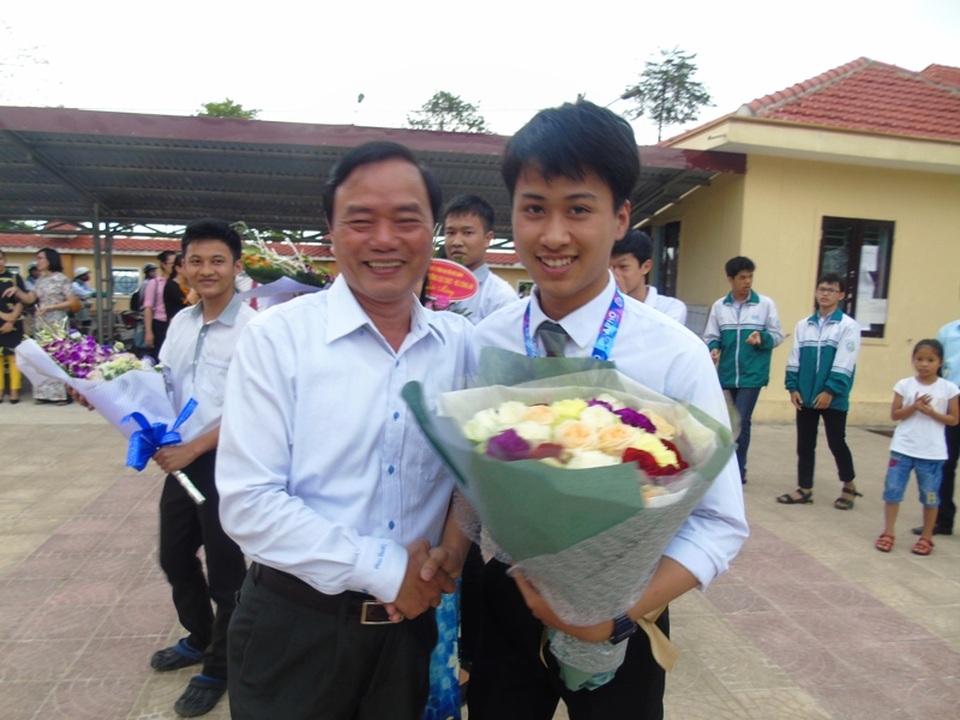 Giám đốc Sở GD-ĐT Quảng Bình Đinh Quý Nhân ra đón và tặng hoa cho chủ nhân của tấm HCB Olympic Vật lý châu Á 2017