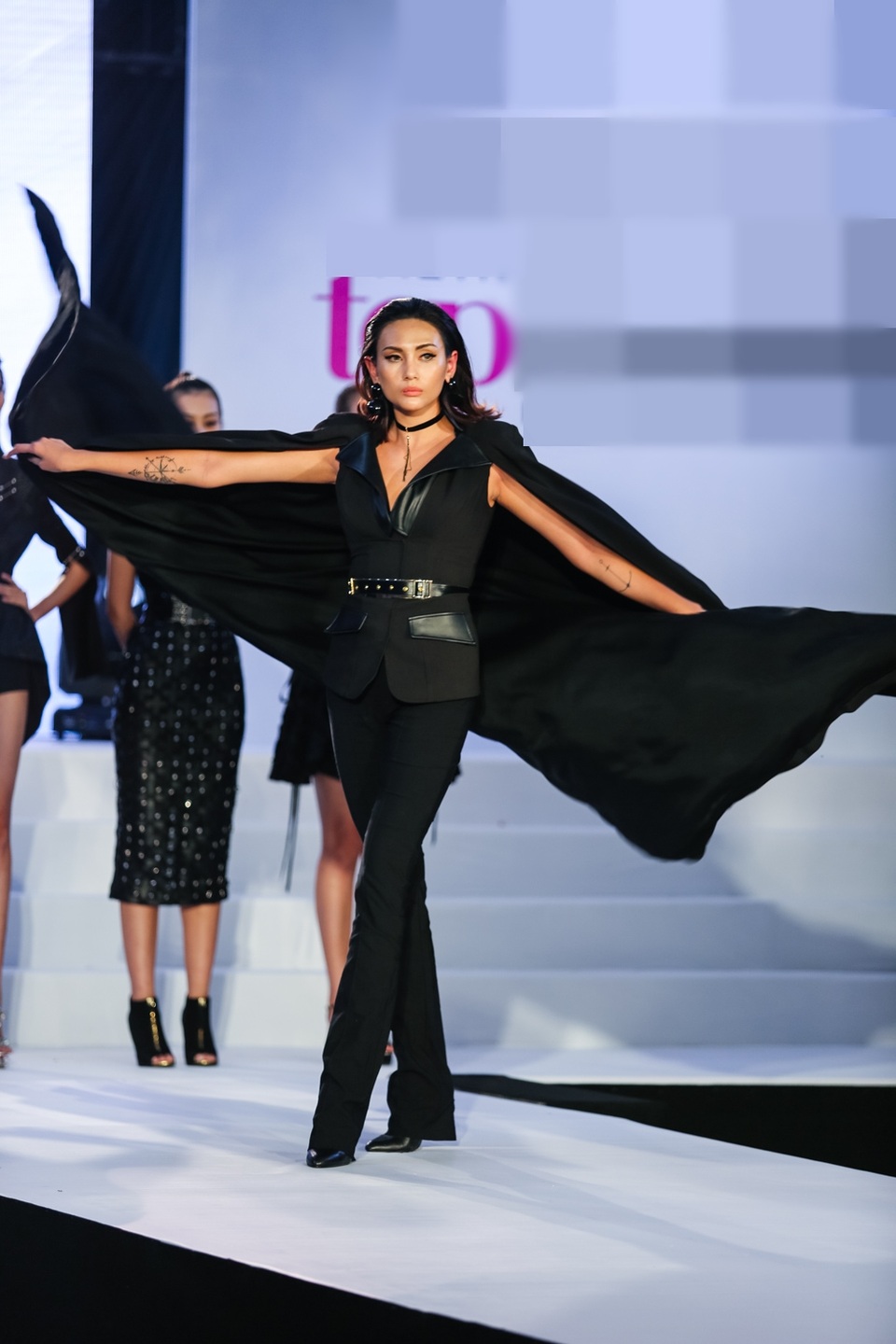 Ngay tại buổi họp báo, Võ Hoàng Yến xuất hiện quyền lực và cá tính trong bộ cánh đen tuyền với chiếc áo choàng ấn tượng. Phong cách thời trang này vốn không có chỗ cho những chiếc vòng cổ choker trẻ trung, năng động, thế nhưng Võ Hoàng Yến vẫn khéo léo “kheo mẽ” xương quai xanh bằng chiếc vòng choker có mặt ánh kim bắt mắt.