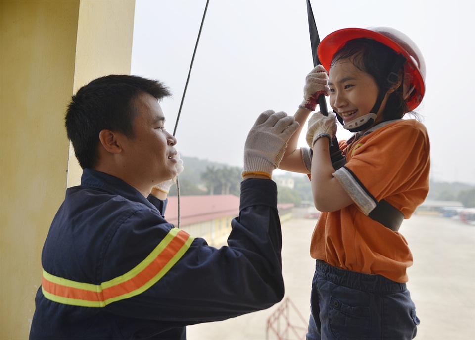 Hàng trăm học sinh học cách thoát hiểm nếu cháy chung cư - 3 Cán bộ PCCC hướng dẫn học sinh đu dây từ nhà cao tầng xuống đất để thoát hiểm khi có cháy.