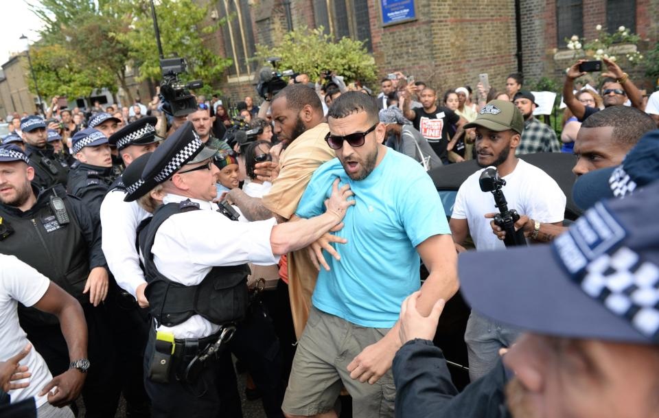 Những người biểu tình giận dữ đã lao về phía Thủ tướng May và la ó bằng những lời chỉ trích nặng nề. Họ gọi bà là “kẻ hèn nhát, kẻ giết người” và yêu cầu bà phải đối chất trực tiếp với người dân về vụ hỏa hoạn kinh hoàng vừa xảy ra. (Ảnh: Metro)