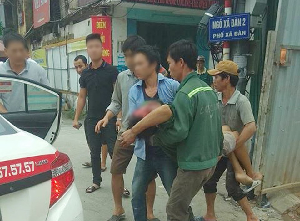 Thùng phuy phát nổ ở Xã Đàn, 1 người bị thương - 1 Nạn nhân được khiêng lên xe taxi đi cấp cứu (Ảnh: Facebook).