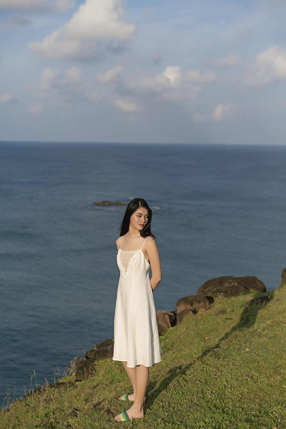 Xuất hiện giản dị trong bộ váy màu trắng, Thùy Dung có cơ hội khám phá, thăm quan, trải nghiệm cuộc sống trên đảo tiền tiêu của đất nước. Đó là đỉnh Cao Cát lộng gió, là phong điện Phú Quý hay bãi biển tràn ngập ánh hoàng hôn ở vịnh Triều Dương... Từ trên đỉnh cao nhất của hòn đảo, Thùy Dung đắm mình vào thiên nhiên, ôm lấy khung cảnh tuyệt đẹp và bao la như say đắm lòng người.