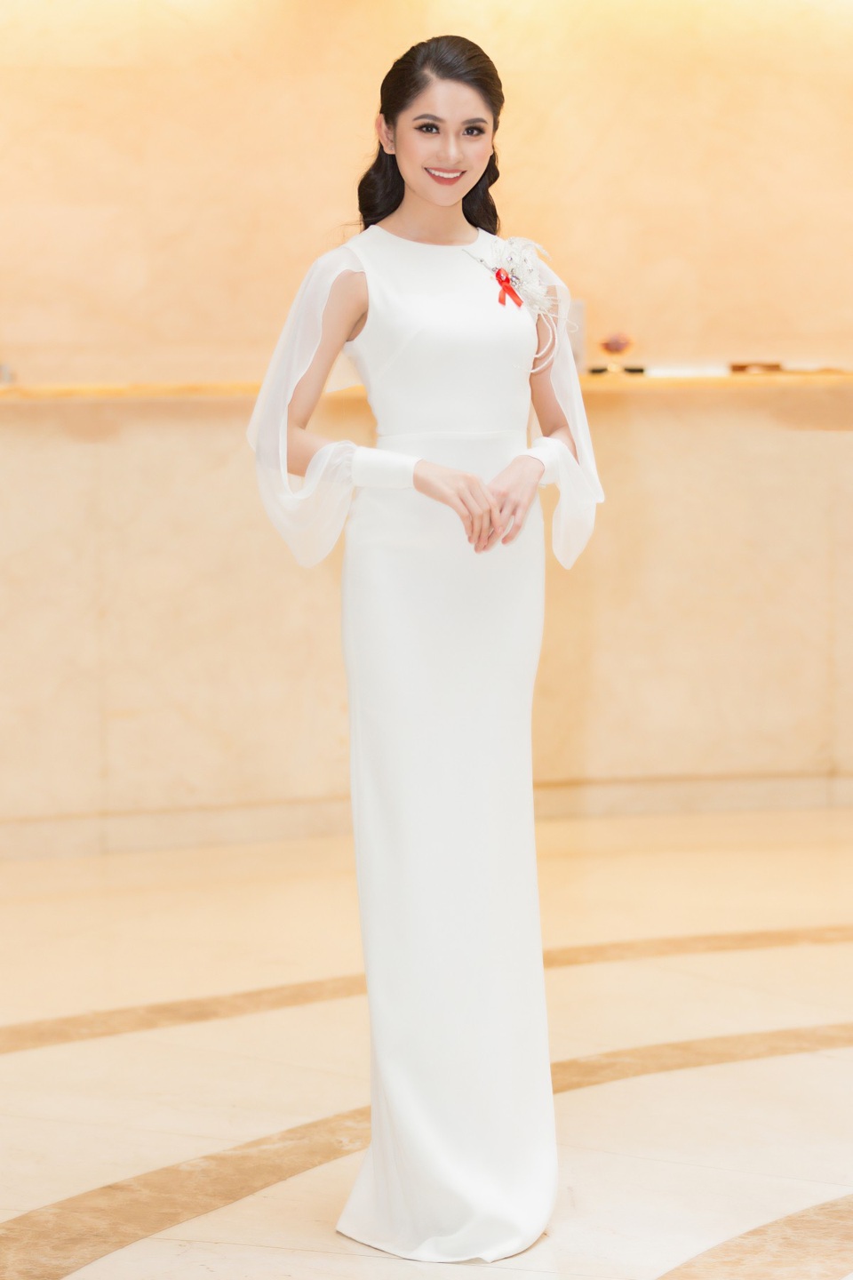 Cô diện chiéc váy gam màu trắng tinh khôi, nhấn nhá bằng con chim hạc được thiết kế riêng.