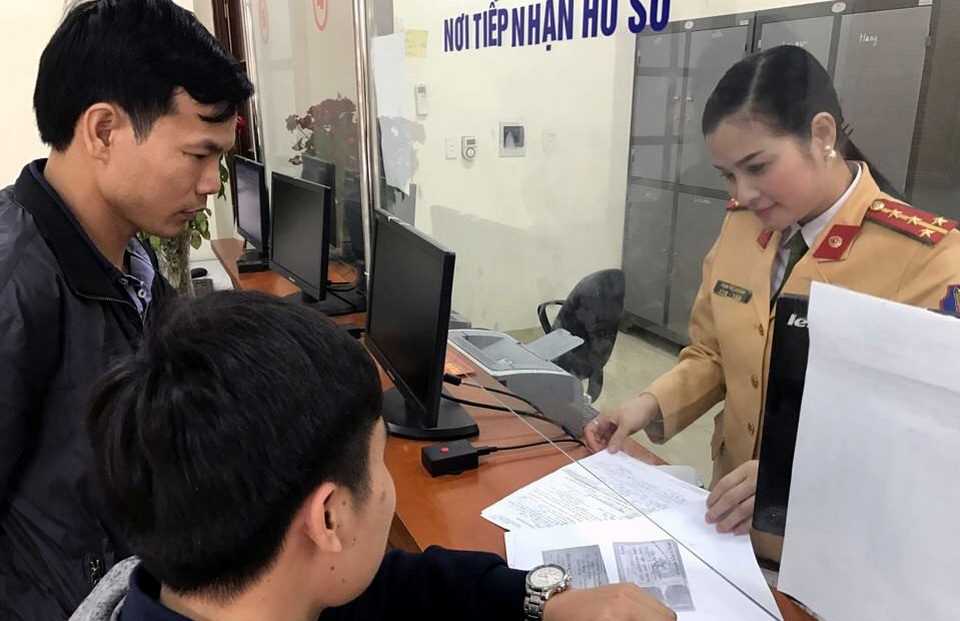 Hà Nội: Đi đăng ký xe, để quên túi xách có 100 triệu đồng - 1
Đại úy Phạm Thị Lan Anh hướng dẫn người dân làm thủ tục đăng ký xe.