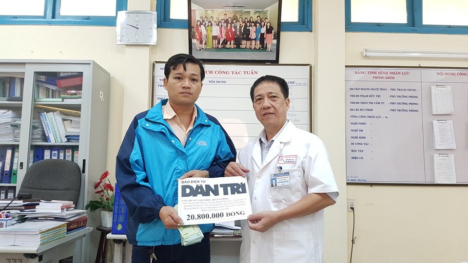 Trao hơn 20 triệu đồng đến con rể chăm sóc mẹ bị ung thư - 2 Anh Dũng nhận tiền từ Quỹ Nhân ái của báo Dân trí do BS Hoàng Bách Thảo, Trưởng phòng Kế hoạch - Tổng hợp, Bệnh viện Trung ương Huế thay mặt trao tặng