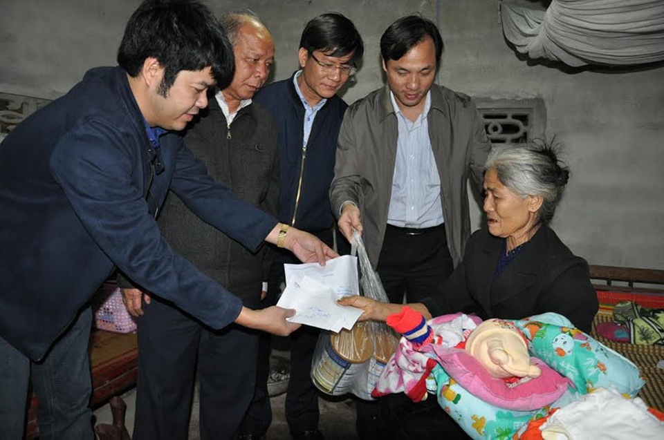 Tết ấm áp của bé 14 ngày tuổi có mẹ bị tâm thần - 3 Trưởng ban tuyên giáo tỉnh Ủy, Hoàng Trung Dũng (ngoài cùng bên phải) cùng PV Dân trí trao quà bạn đọc cho gia đình bà Hoài.