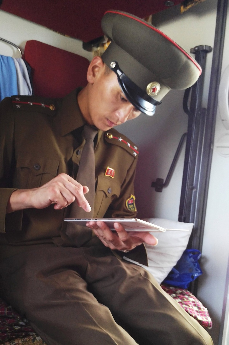Góc nhìn hiếm có về Triều Tiên từ ô cửa tàu hỏa - 10 Một sĩ quan hải quan kiểm tra máy tính bảng của ông Chu trên tàu để đảm bảo rằng thiết bị này không gắn phần mềm định vị.