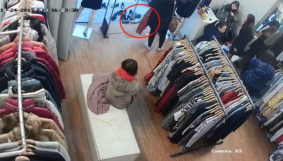 Người phụ nữ mang chiếc áo ra thử xem cửa từ có hoạt động hay không. (Ảnh cắt từ clip)